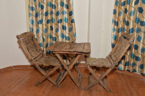 a pair of chairs and a table next to a curtain at The Hidden Cove in Bhīm Tāl
