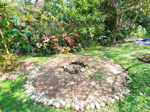 a garden with a circle of rocks in the grass at Habitación grupal en San Carlos con acceso al rio y desayuno incluido in San Carlos