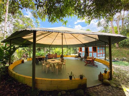 a patio with tables and chairs under a large umbrella at Habitación grupal en San Carlos con acceso al rio y desayuno incluido in San Carlos