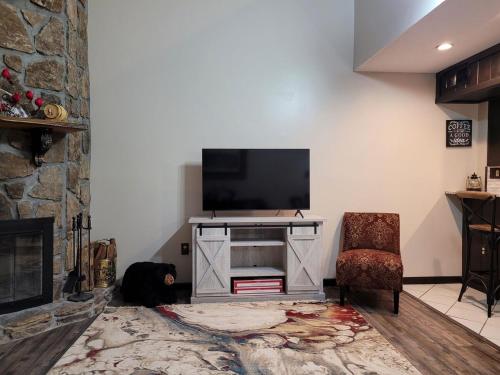 a dog laying on the floor in a living room with a television at Little Womens Villa Condo 1 mile from Parkway in Gatlinburg