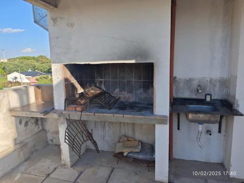 an outdoor kitchen with a fireplace and a sink at Terrazas de la Colina in Victoria