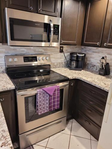 a kitchen with a stove top oven with a microwave at Little Womens Villa Condo 1 mile from Parkway in Gatlinburg