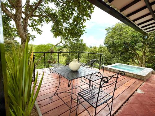 a wooden deck with a table and a vase on it at Finca Hotel Sol Y Luna in Calarcá