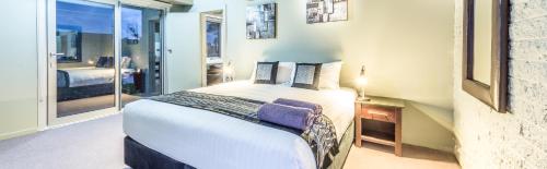 a bedroom with a large white bed and a window at Orbost Motel in Orbost