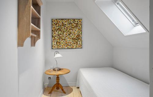 a room with a bed and a table with a lamp at Cozy Home In Thyborøn With Wifi in Thyborøn