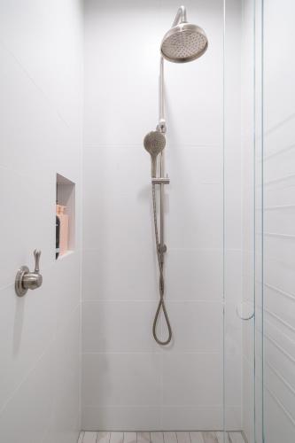 a shower with a shower head in a bathroom at New Penthouse with Ocean & Golf Course Views in Collaroy