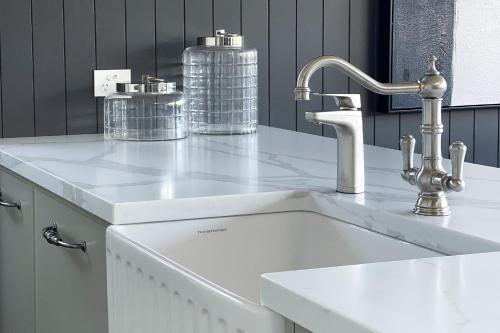 a white kitchen with a sink and a faucet at New Penthouse with Ocean & Golf Course Views in Collaroy