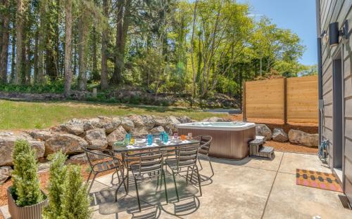 a patio with a table and chairs and a hot tub at Harbor Lights 3 New 2024, Hot Tub, Pet OK in Depoe Bay