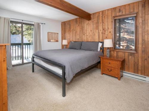 a bedroom with a bed and a wooden wall at 4479 Timber Falls 2001 in Vail