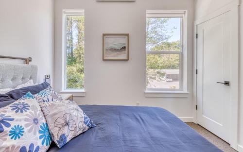 a bedroom with a blue bed and two windows at Harbor Lights 4 - Whale Watcher's HavenFamily Fun in Depoe Bay