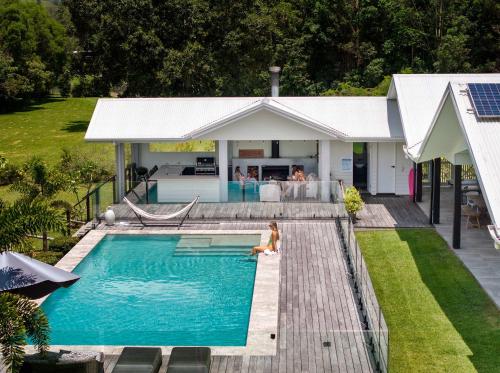 a woman sitting in a swimming pool next to a house at Luxury Modern Country Retreat in Kin Kin