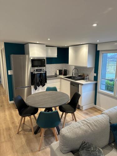 une cuisine avec une table, des chaises et un canapé dans l'établissement Fully-equipped new apartment, à Saint-Germain-Lembron