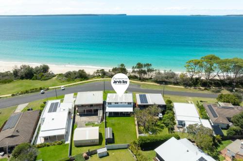 an aerial view of a house with the ocean in the background at Villa Killara by Experience Jervis Bay in Vincentia