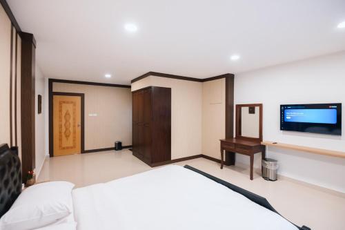 a bedroom with a bed and a flat screen tv at Ng Cozy Retreat in Sathani Khlong Rian
