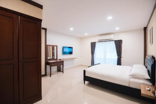 a bedroom with a bed and a desk in it at Ng Cozy Retreat in Sathani Khlong Rian