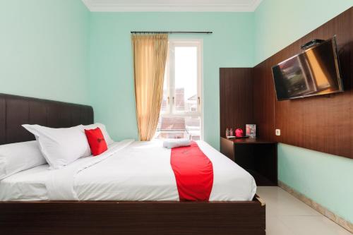 マランにあるReddoorz near Universitas Widyagama Malang 2のベッドルーム1室(赤い毛布付きのベッド1台付)