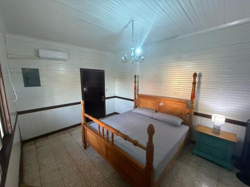 a bedroom with a bed and a chandelier at Casa Maita Guanacaste in Palmira