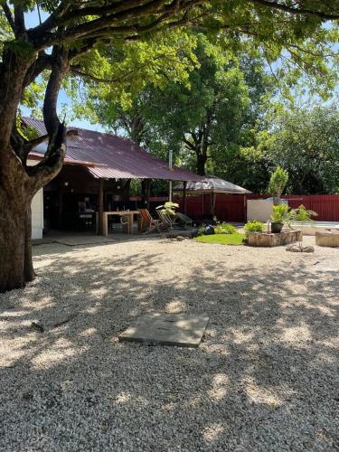 a building with a table and a tree in a yard at Casa Maita Guanacaste in Palmira