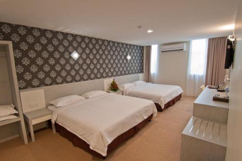ein Hotelzimmer mit 2 Betten in einem Zimmer in der Unterkunft De Spring Hotel in Kuantan