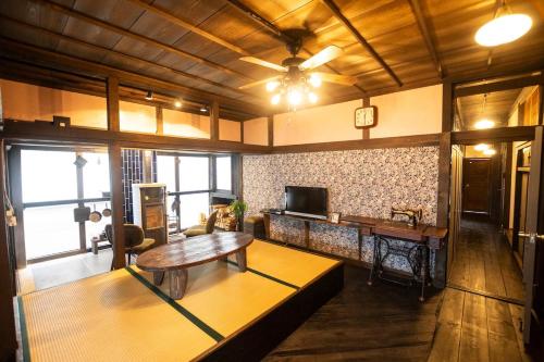 a living room with a table and a tv at Epion 1 Good access to Kamikochi and Ukiyoe Museum, rent a Japanese Farm House in Matsumoto