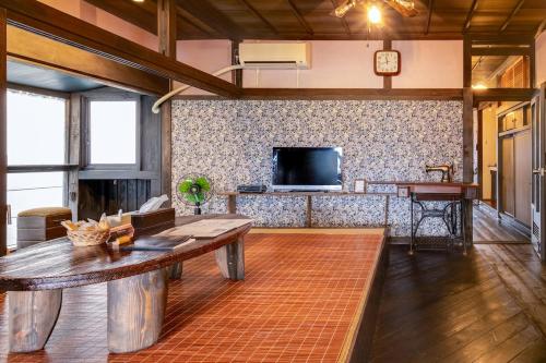 a living room with a table and a tv at Epion 1 Good access to Kamikochi and Ukiyoe Museum, rent a Japanese Farm House in Matsumoto