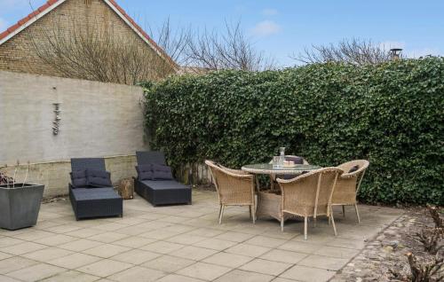a patio with a table and chairs and a fence at Cozy Home In Thyborøn With Wifi in Thyborøn