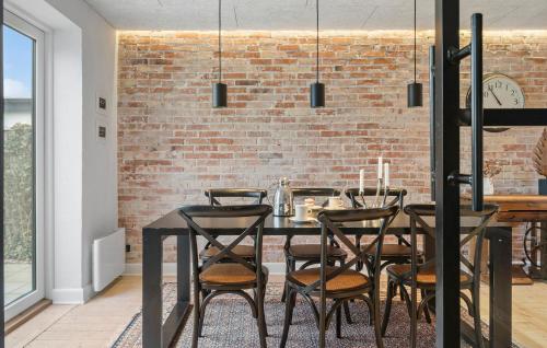 a dining room with a brick wall and a table and chairs at Cozy Home In Thyborøn With Wifi in Thyborøn