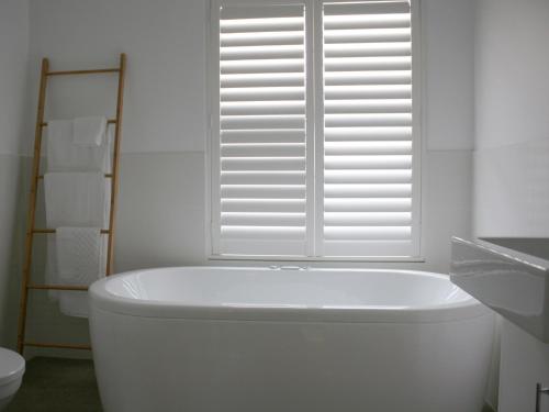 a white bath tub in a bathroom with a window at Haven on the Park in Perth