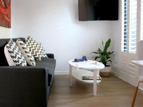 a living room with a couch and a table at Haven on the Park in Perth
