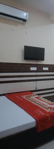 a bedroom with a bed with a red blanket on it at New Gayatri place Near by prem mandir in Dānītola