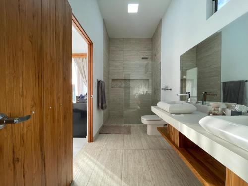 a bathroom with a sink and a toilet and a tub at Casa Kairos CR, Playa Samara in Nicoya