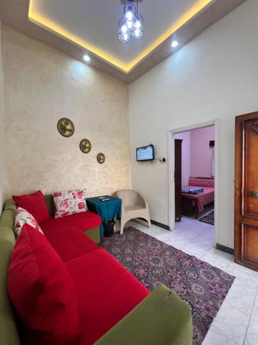 Una sala de estar con un sofá rojo y una mesa. en Cozy airconditioned two bedroom apartments شقق فندقية مكيفة للإيجار, en Ras El Bar