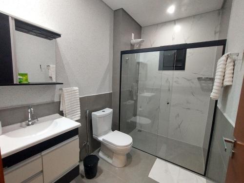 um banheiro com chuveiro, vaso sanitário e pia em Residencial Verônica 06 - Apartamento de 1 quarto próximo ao centro em Marília