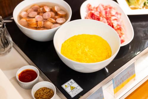 a counter top with bowls of food and other ingredients at Natural Hot Spring Ariston Hotel Oita in Oita