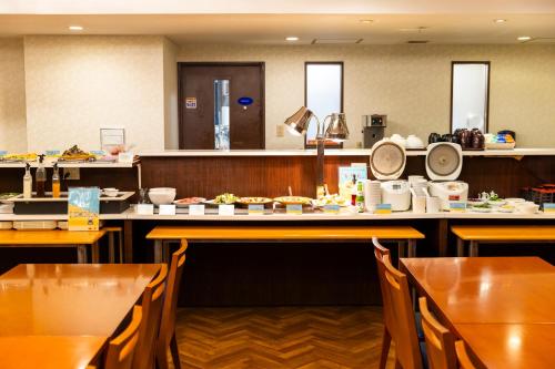 a restaurant with tables and chairs with food on them at Natural Hot Spring Ariston Hotel Oita in Oita