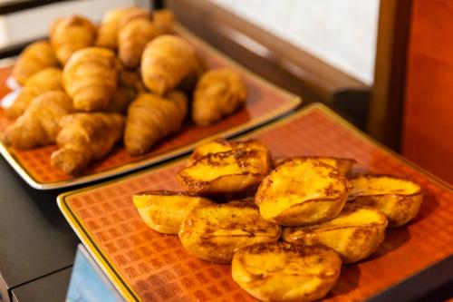 a table with a plate of bread and pastries at Natural Hot Spring Ariston Hotel Oita in Oita
