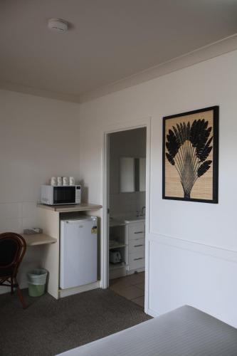 a room with a kitchen with a refrigerator and a microwave at Park Avenue Hotel Motel in Rockhampton