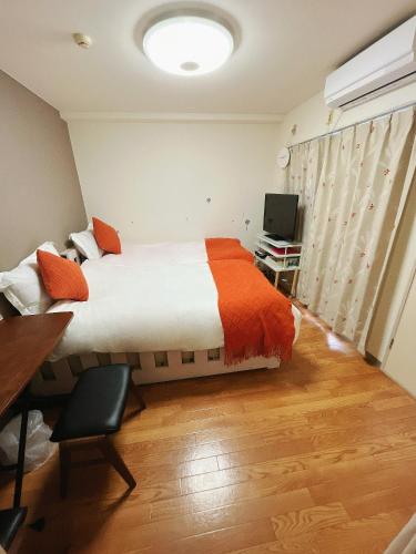 a bedroom with a bed and a desk and a television at ToyamaHouse2-202 in Tokyo