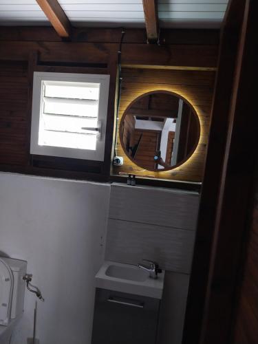 a small bathroom with a mirror and a sink at Bungalow Steens in Le Gosier