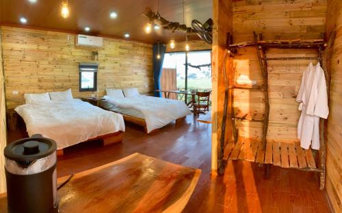 a bedroom with two beds and a wooden wall at A Thía homestay in Diện Biên Phủ