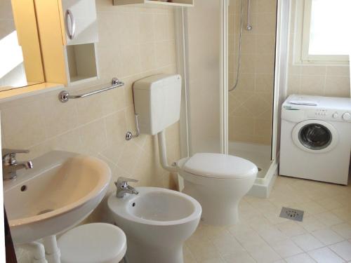 圣玛格丽塔波尔勒港Villa in Caorle near Spiaggia Tartaruga的带马桶、水槽和洗衣机的浴室