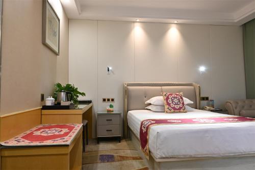 a hotel room with a bed and a table at Dunhuang Hotel in Dunhuang