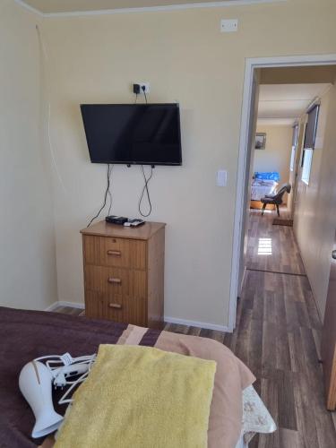 a bedroom with a television on a dresser with a bed at Departamento en Quiriyuca in Puchuncaví