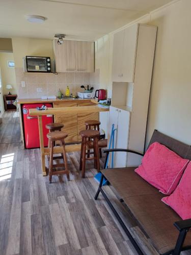 a kitchen with a couch and a table with stools at Departamento en Quiriyuca in Puchuncaví