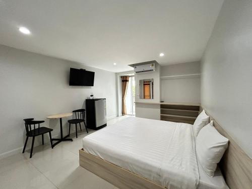 a bedroom with a bed and a table with chairs at DD Boutique Resort in Ban Wat Pa