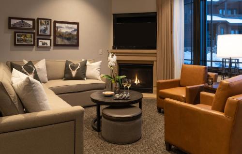 a living room with a couch and chairs and a fireplace at Waldorf Astoria Park City in Park City