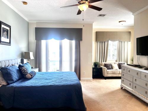 a bedroom with a blue bed and a television at Luxury Villa 5 Bedrooms Minutes from Disney in the Reunion resort in Kissimmee