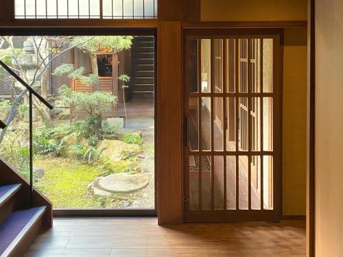 an open door with a view of a garden at Muromachi Yutone Kyokoyado in Kyoto