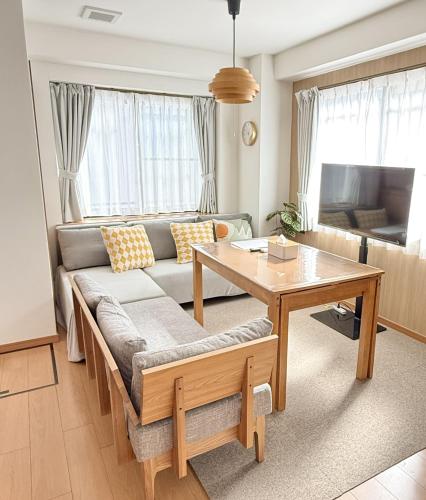 a living room with a couch and a table at JR Soubusen Hirai 5mins walk Guest house! 2LDK,Max 8PP! Direct access to Kinshicyo,Akihabara,Shinjyuku! in Tokyo