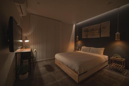 Un dormitorio con una cama, un escritorio y un televisor. en INFINITY HOTEL -Higawa-, en Naha